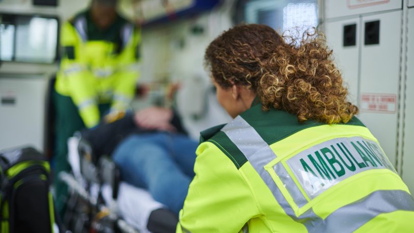 two paramedics attend to a patient on a stretcher