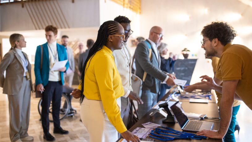 A group of conference participants registering for a conference in the lobby of a hotel.